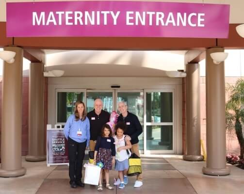 5 people under maternity entrance banner