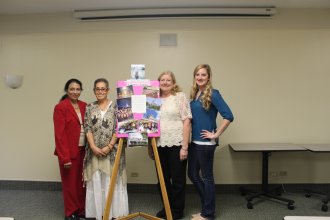 4 women standing by an easel 